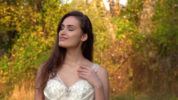 Beautiful Bride Is Posing at the Sunset Against Autumn Nature. Video Shooting Movement Camera with