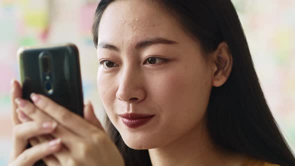 Handheld View of Focused Young Woman Looking at Mobile Phone