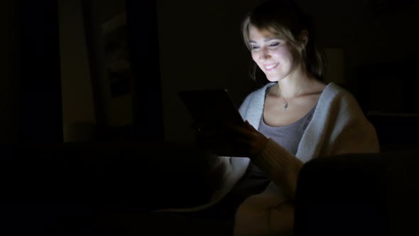 Woman Reacting to Success while Using Tablet at Night