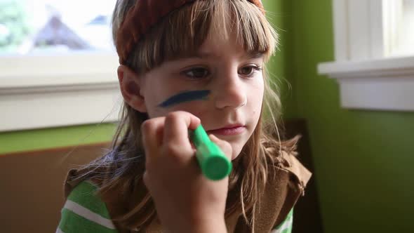 Girl dressed as Native American having face painted