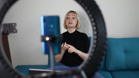 Woman Talking to Camera and Recording Video with Smartphone and Ring Light Lamp at Home Vlogger