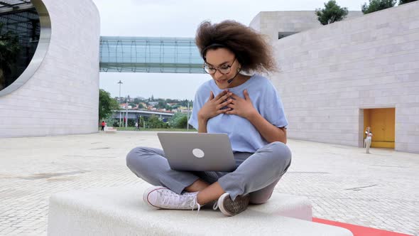 Busy Successful African American Young Woman with Headset Business Lady Sitting Outdoors Holds