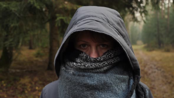 Portrait of a Girl in Winter Clothes Hiding Her Face with a Scarf