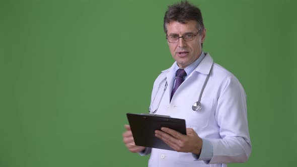 Mature Handsome Man Doctor Against Green Background