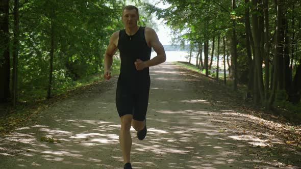 Morning Jog Pro Runner on a the Forest Road Athlete Trains in Nature Environment Triathlon