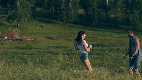 Young Woman Runs To Man in Denim Dressing and Kisses