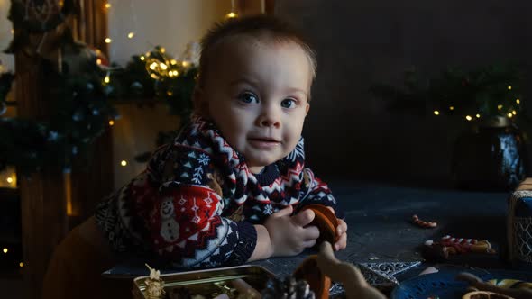 Baby Boy with Christmas Baubles at Home