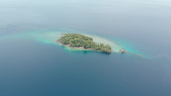 Aerial: flying over tropical island Banda Islands Maluku Indonesia Maldives Poly