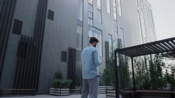 Businessman Texting Standing at Modern Glass Office Building