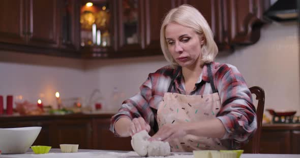 Portrait of Focused Young Woman Kneading Flour As Boy Bringing Phone and Leaving