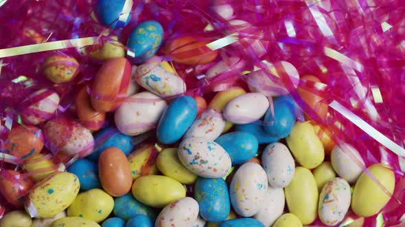 Rotating shot of colorful Easter candies on a bed of easter grass - EASTER