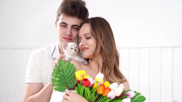 a Man Gave His Beloved Woman a Bouquet of Colorful Tulips and a White Kitten