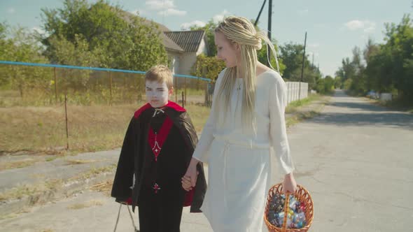 Sibling in Halloween Costumes Walking Outdoors