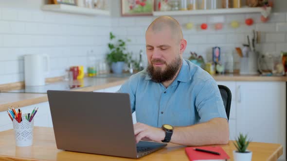 Mature Bearded Man Working or Studying Remotely at Home