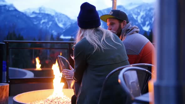 Couple interacting nearby campfire