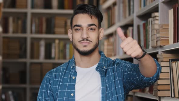 Closeup Young Happy Guy Standing in Library Looking at Camera Joyful Student Showing Thumb Up