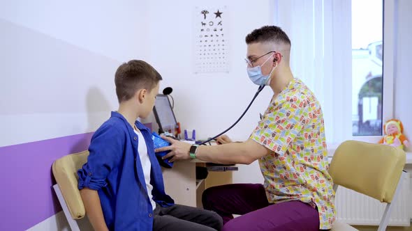 Doctor measuring blood pressure of a child in examination room