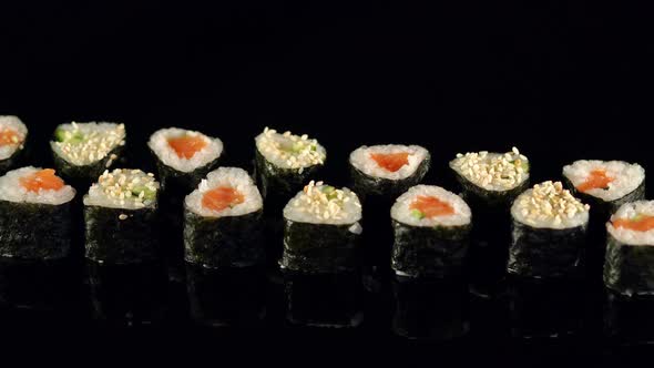 Girl Takes Chopsticks Sushi on Black Background