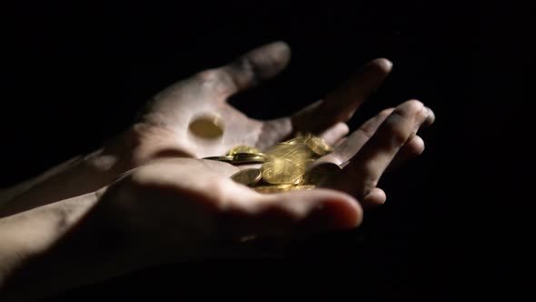 Gold Coins Falling Dirty Hands of Worker on Black Background. Concept of Jackpot Lottery