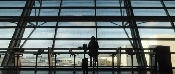 Woman silhouette sitting in front of big terminal window. BMPCC 4K