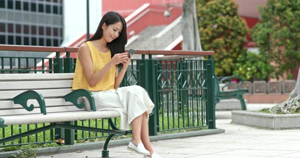 Woman use of cellphone at outdoor park