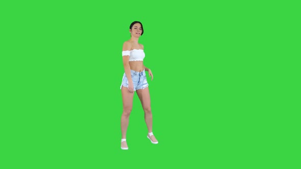 Adorable Hispanic Female Model in Denim Shorts Dancing on a Green Screen, Chroma Key