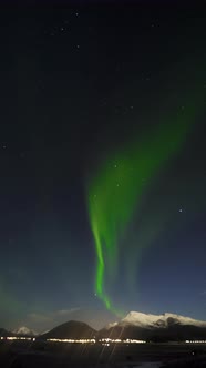 Timelapse of Northern Lights in Sky and Glare of Lights From Street By Lake