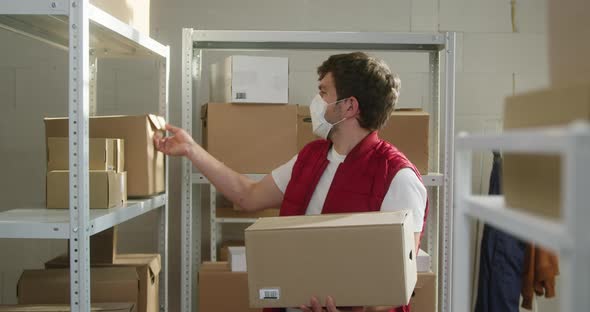 Man Wearing Red Vest Taking Parcels Employee of Warehouse in Medical Face Mask Takes Delivery Boxes