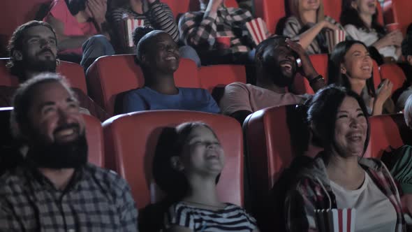 Joyful Spectators Watching Comedy in Movie Theater
