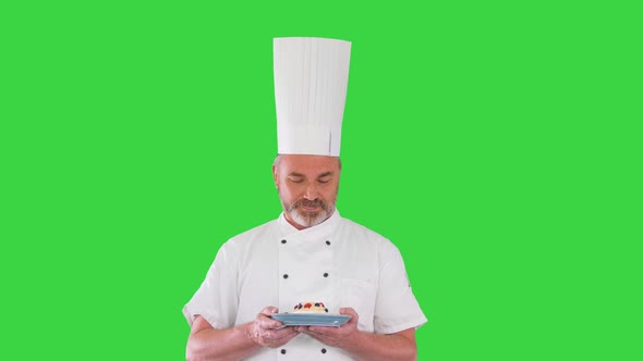 Bearded Male Chef Cook Making Delicious Gesture with Dessert in His Hands on a Green Screen Chroma