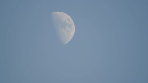 Half Crescent moon against blue sky