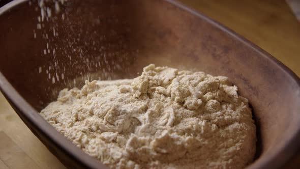 BAKING - Sprinkling flour during sourdough bread baking, slow motion