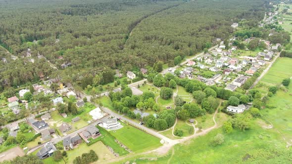 Small Lithuanian town with forest and river on sides, aerial view