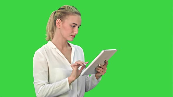 Concentrated Businesswoman Standing with Digital Tablet on a Green Screen