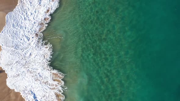 Aerial view of a wave breaking onto Papohaku Beach, Maui County, Hawaii