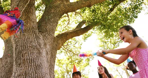 Girl hitting a multicolored puppet with stick