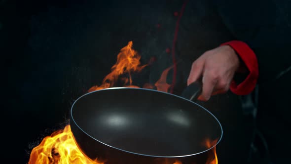 Super Slow Motion Shot of Chef Holding Empty Frying Pan and Flames at 1000Fps.