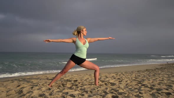 A young attractive woman doing yoga on the beach