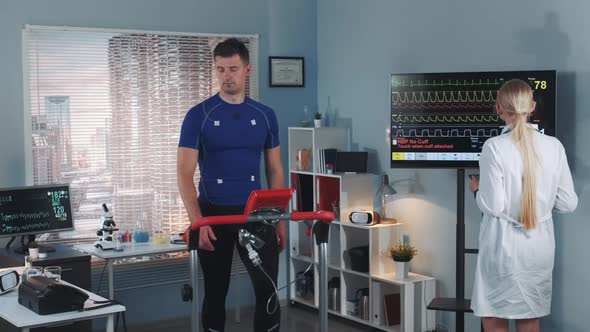Female Cardiologist Coming To Examine Athlete Stress Testing on Treadmill alt