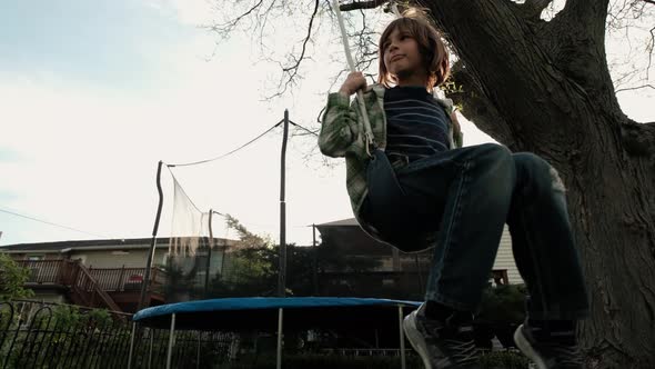 Boy Having Fun on Chain Swing on Playground