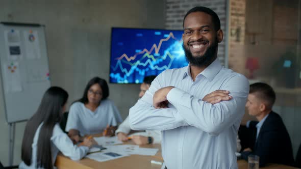 Portrait of Confident Smiling African American Businessman Posing with Folded Arms and Widely