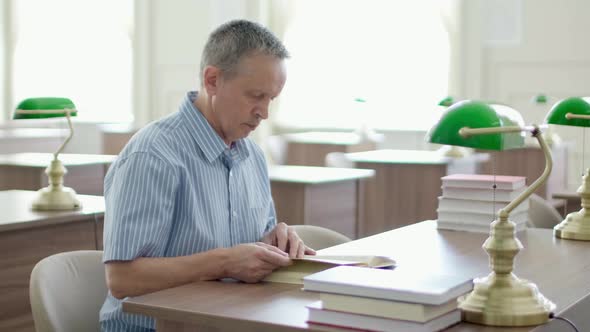 Senior Man with Mustache Reading a Book