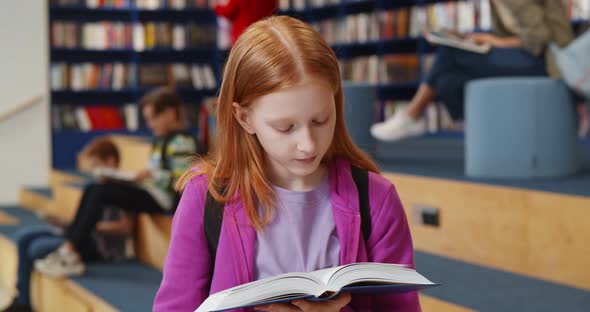 Redhead Student Girl Reading Book at School Library