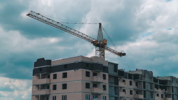 Timelapse footage of a high crane works on building site with a house