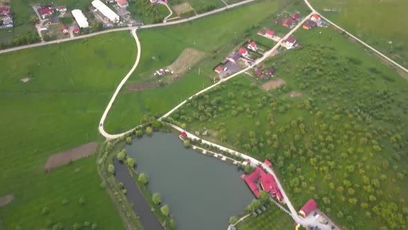 Aerial view of a fishing pond near a city, Transylvania, Romania. Tilting up