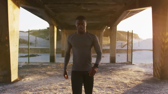 Portrait of focused african american man walking to camera, exercising outdoors in the evening