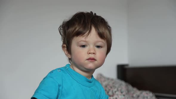 Little toddler boy lloking at camera at home