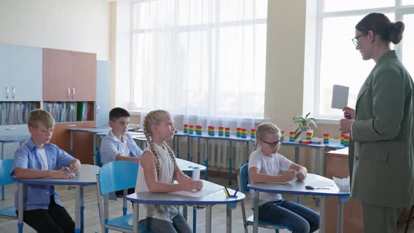 Teacher Shows Cards with Assignment for Pupils Children Raise Hands Knowing the Correct Answer While