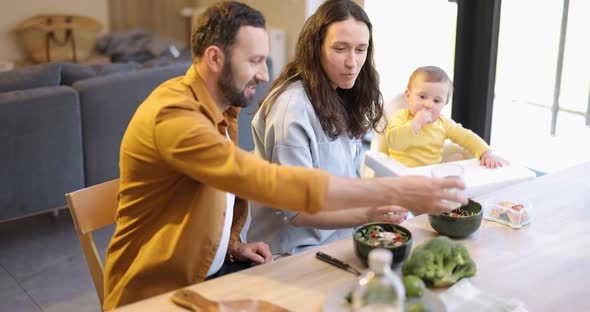 Young Family with a One Year Baby Boy During a Lunch Time at Home