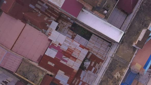 Top down drone shot with view of the old and worn out roof in the asian village and town centre in I